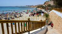 Stone pathway with fence going down to La Caleta beach in Cabo Roig
