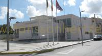 Rådhuset i Benijofar med flaggor och ljusstolpar framför.